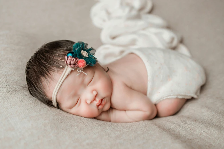 a newborn girl wearing a flower in her hair