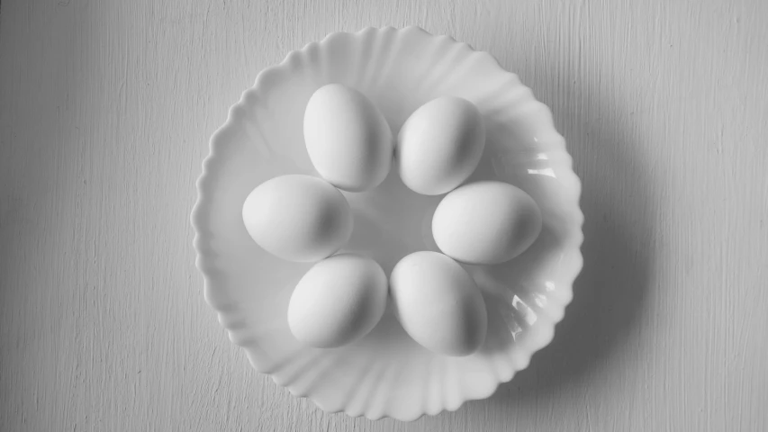 a bowl on a table filled with nine eggs