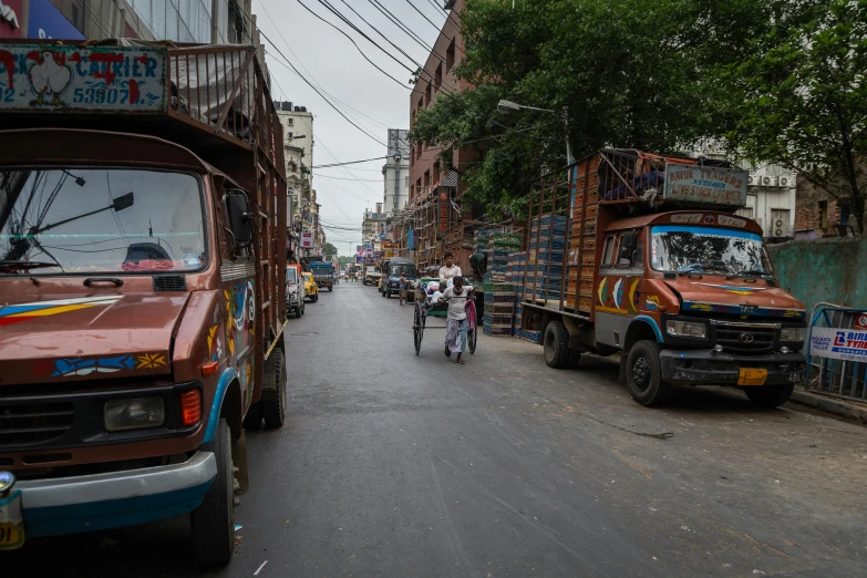 vehicles with people and bicycles traveling down a busy street