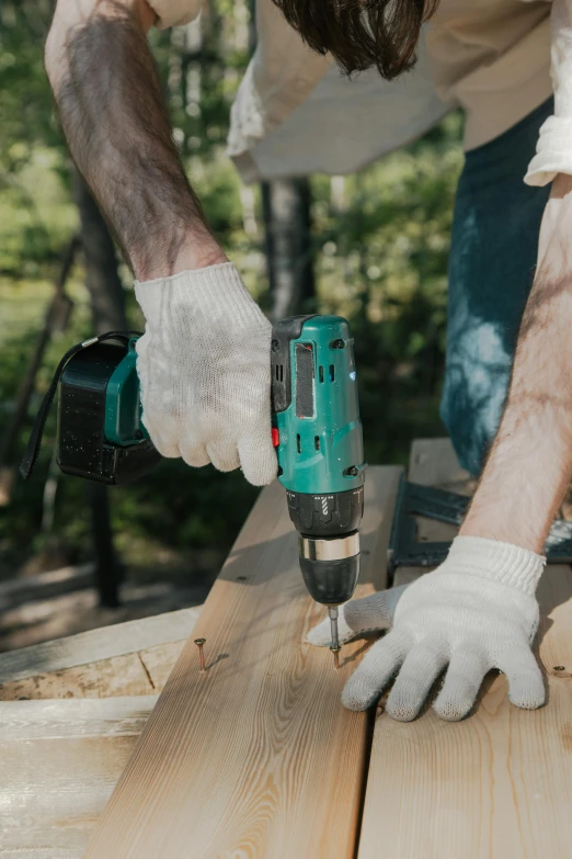 a man using a driller on a piece of wood