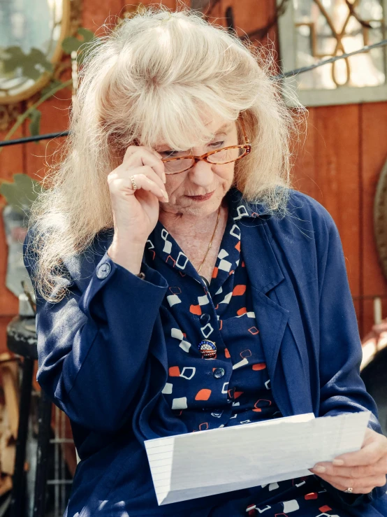 woman in blue jacket sitting and talking on her phone