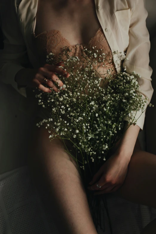 a woman wearing a shirt holding a bunch of flowers