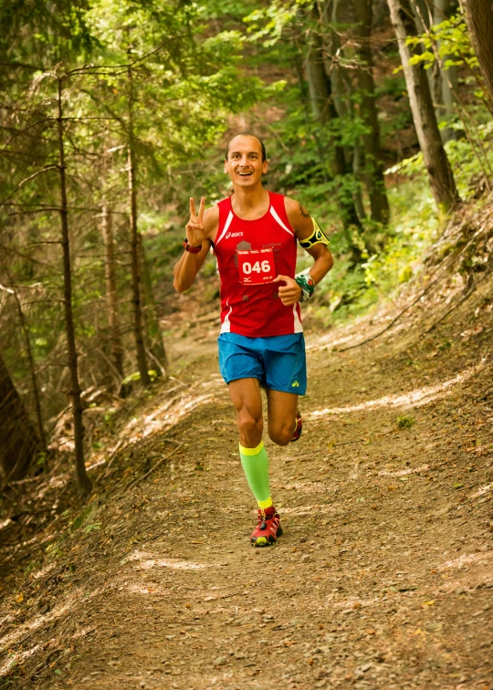 a man running on the trail with a glove in his hand