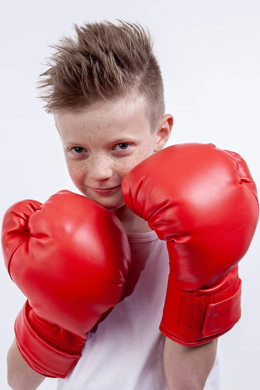 a child standing and holding two boxing gloves