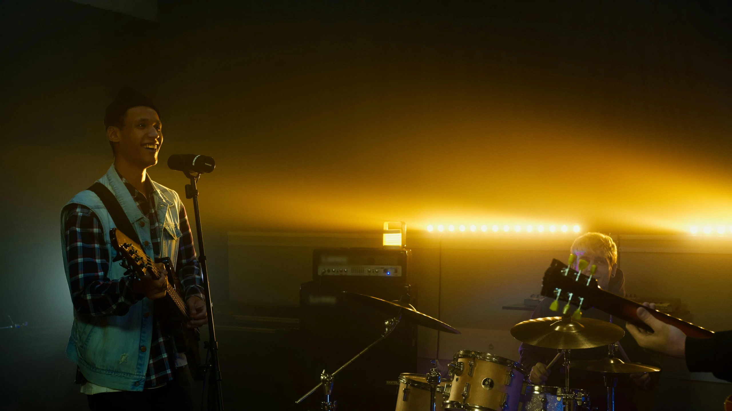 two musicians on stage playing instruments and lighting