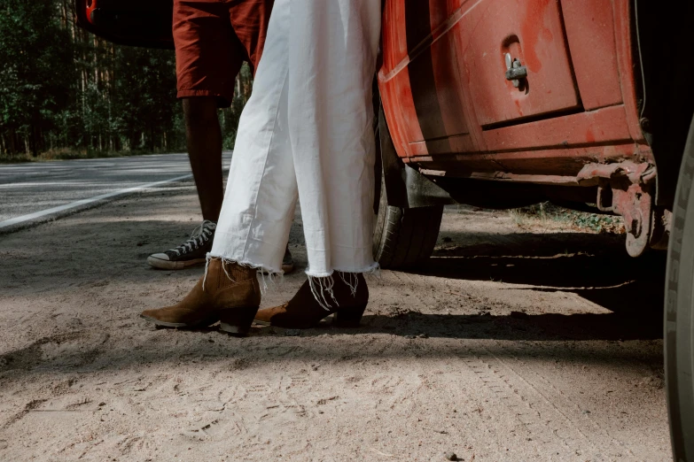 people wearing white pants are standing in front of a red truck