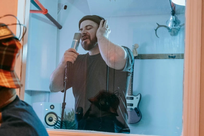 man using phone with his headphones while talking into microphone