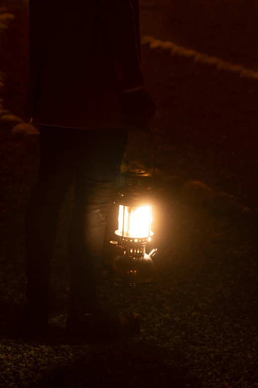 a person standing with their back against a street lamp