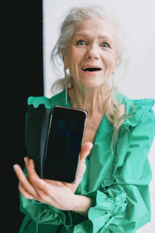 a woman in a green shirt holding an empty phone