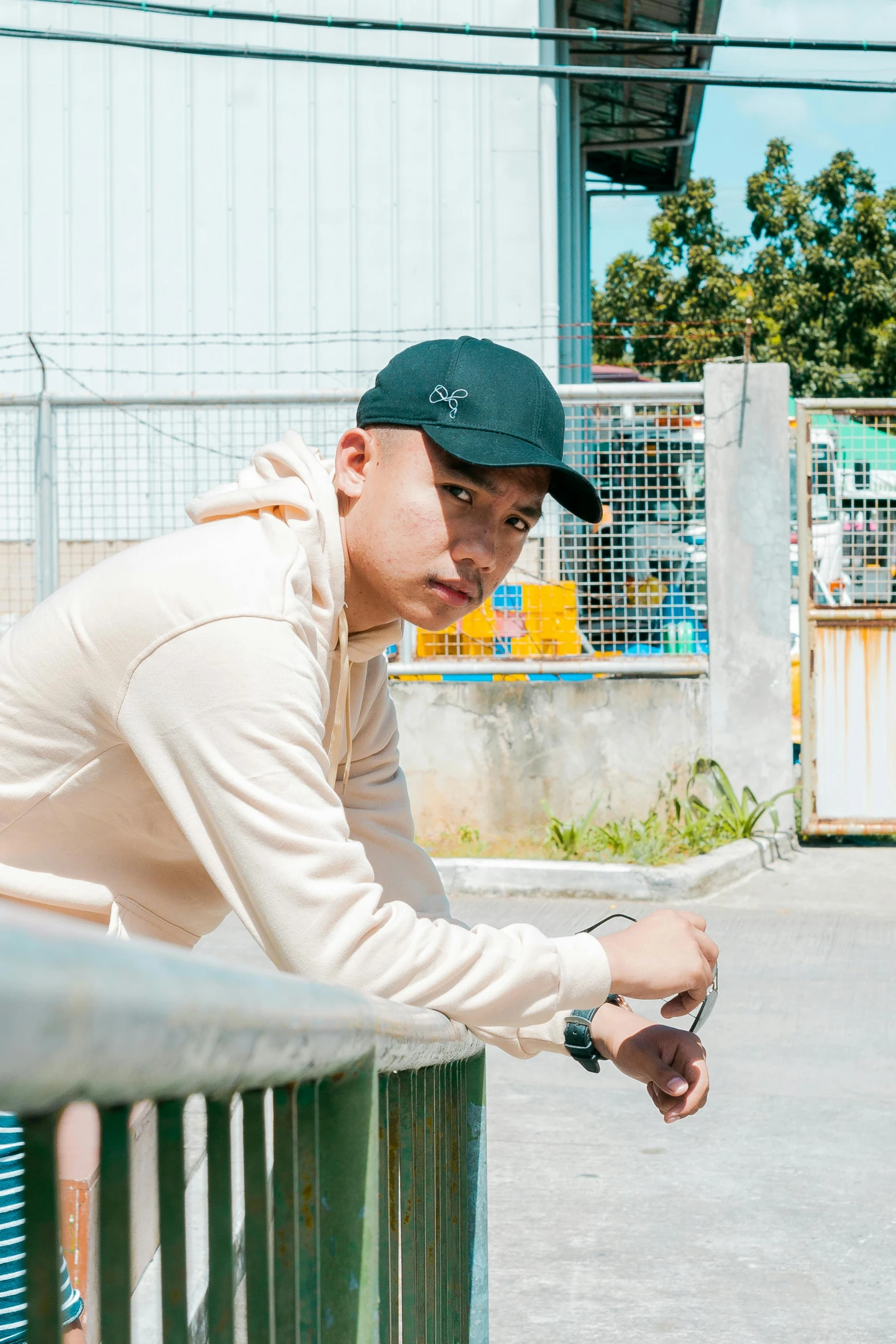 a man leaning over a fence looking down at his watch