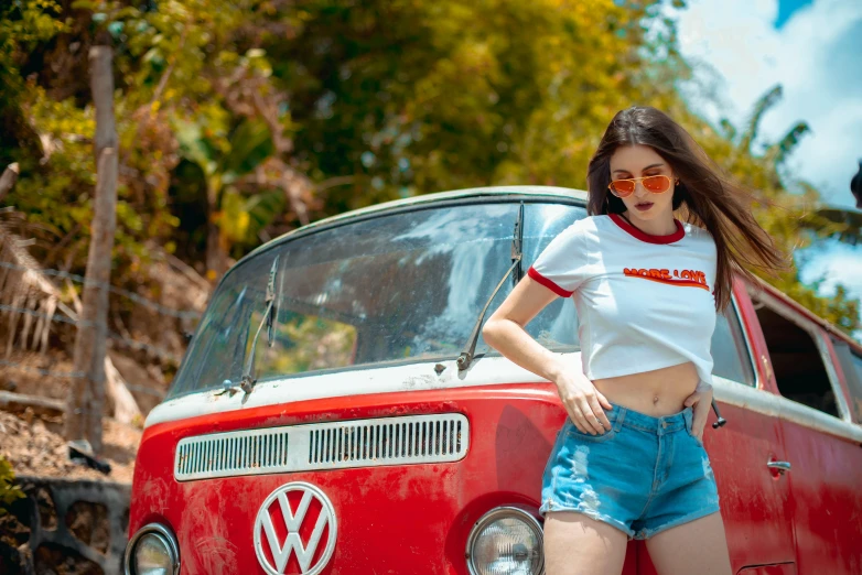 a women is standing next to an old vw van