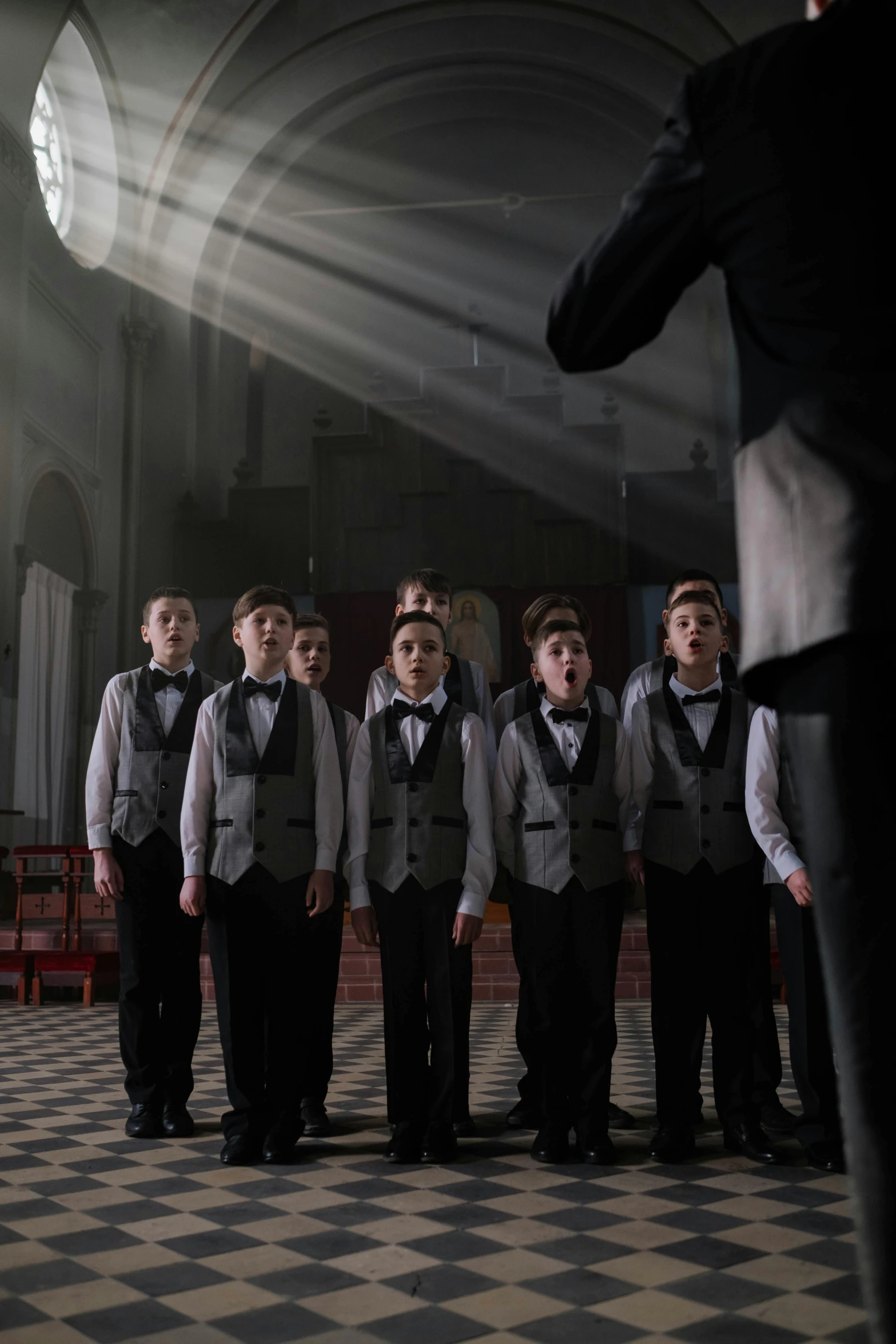 young men in tuxedos are standing in a row