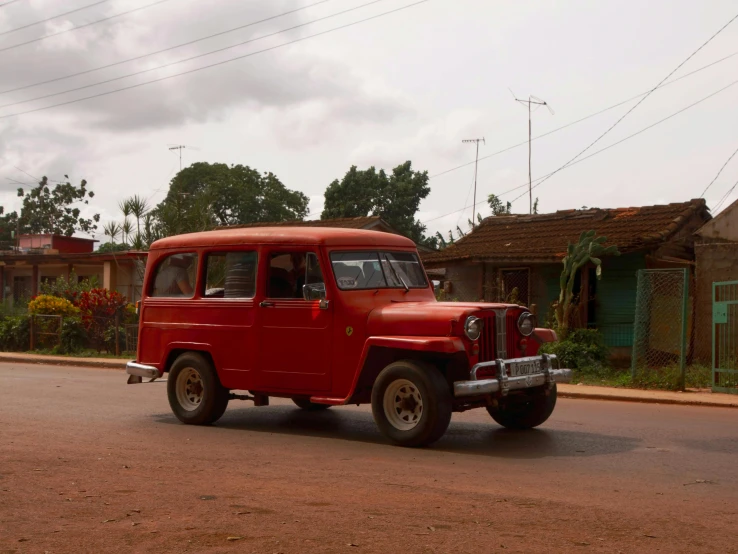 an old jeep traveling on a rural road