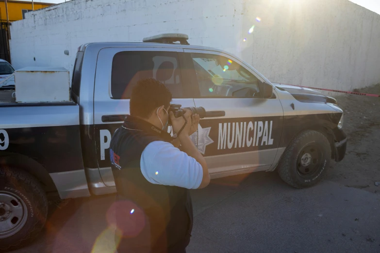 a police officer takes a po of the scene on a street