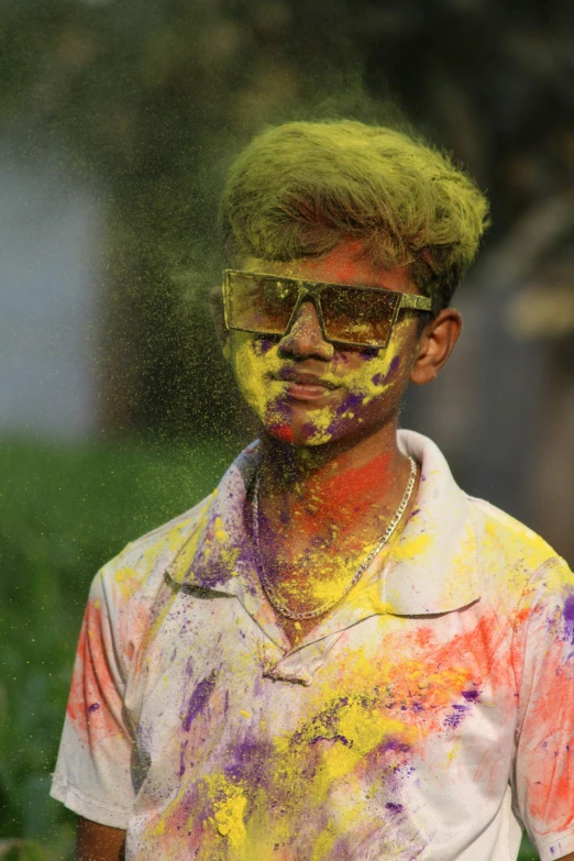 a man in sunglasses is covered in colored powder