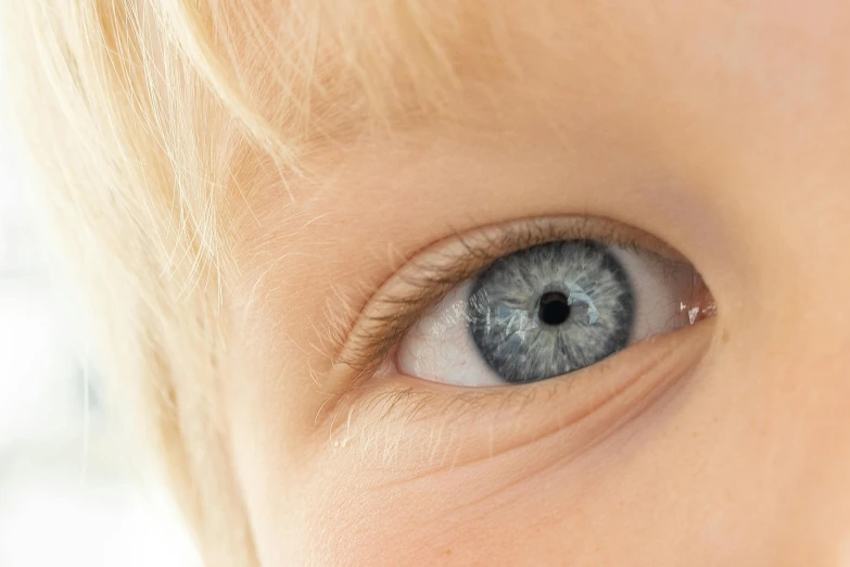 a young child is looking up with a blue eyeshadow