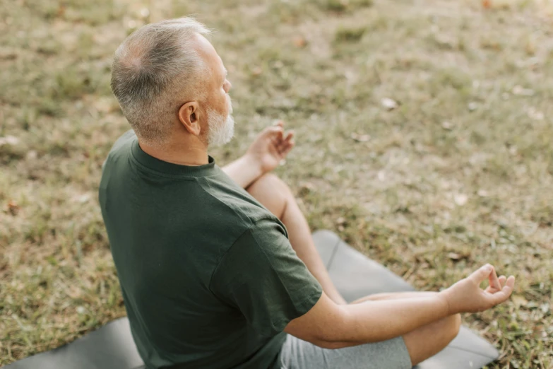 an older man sitting in a yoga pose