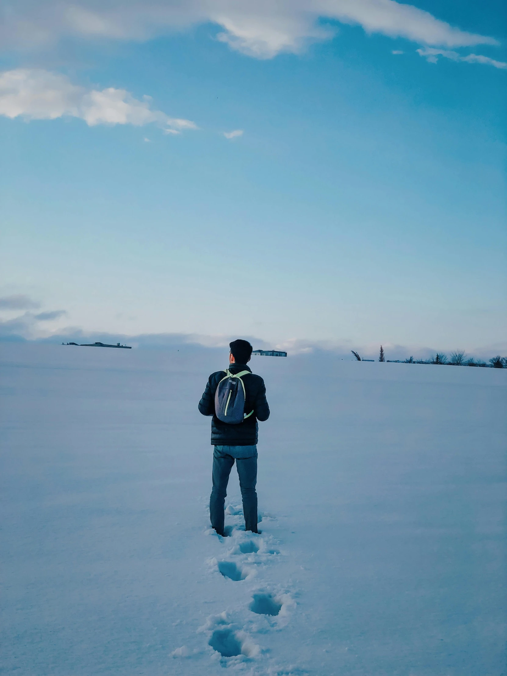 a man standing in the snow wearing a snowboard