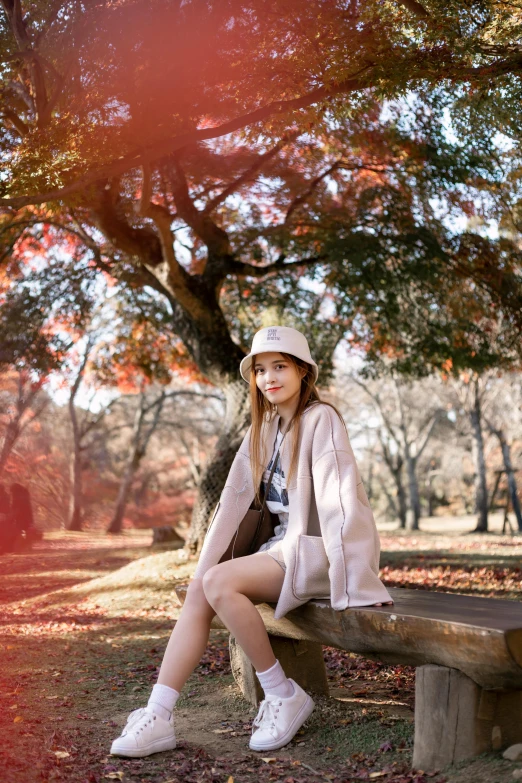 a woman sitting on top of a bench in a park