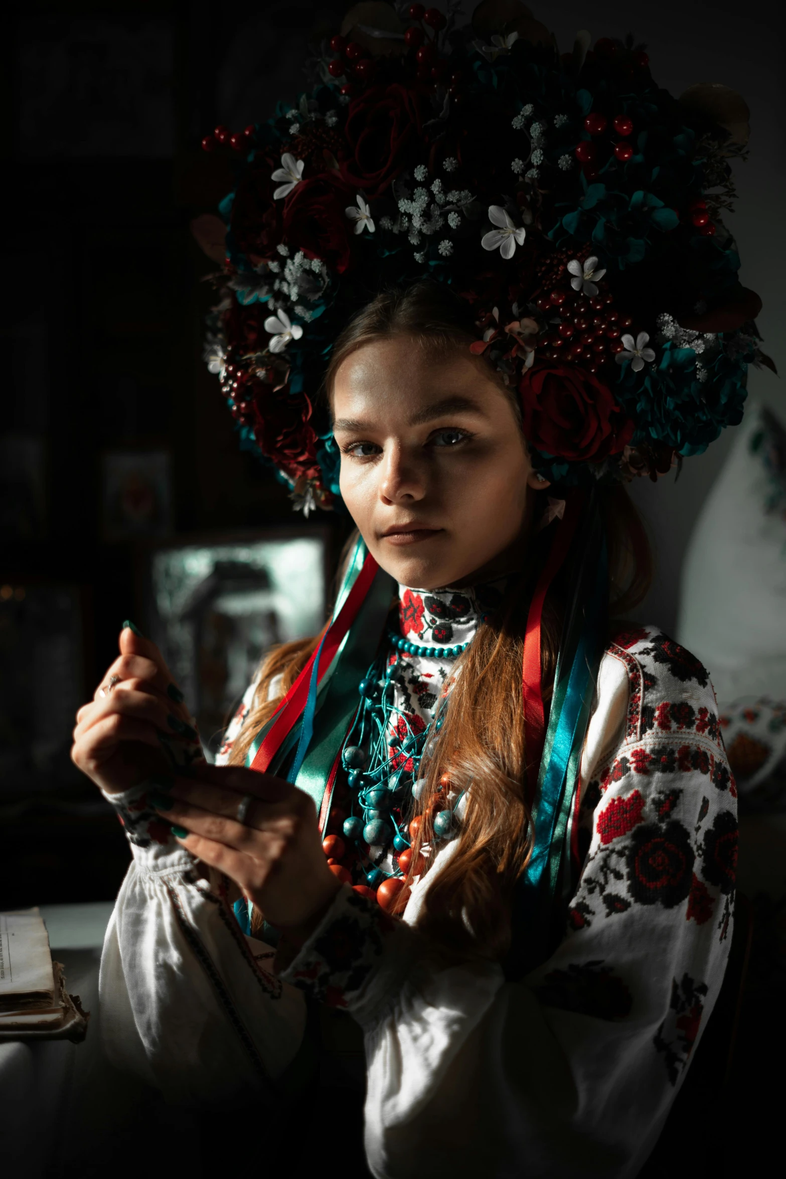 young woman with multicolored flowers on her head using a cell phone