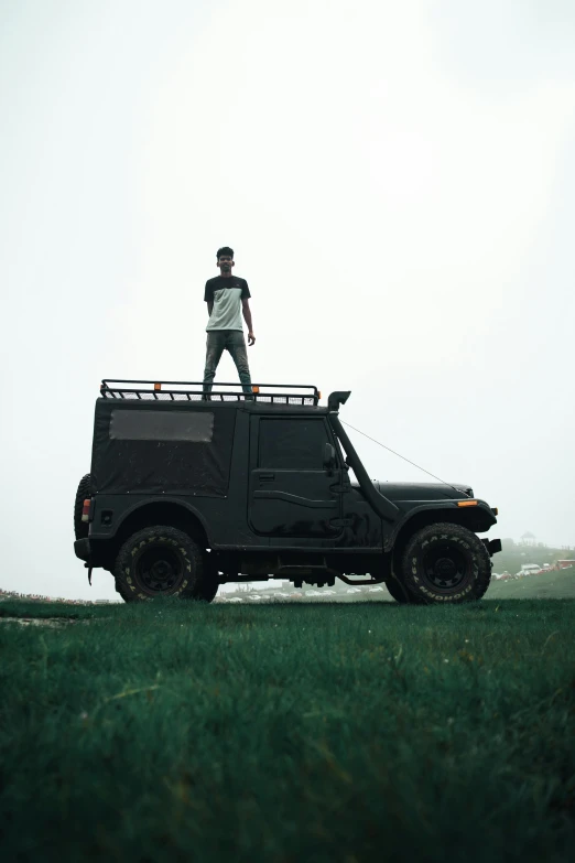 man standing on top of a black jeep