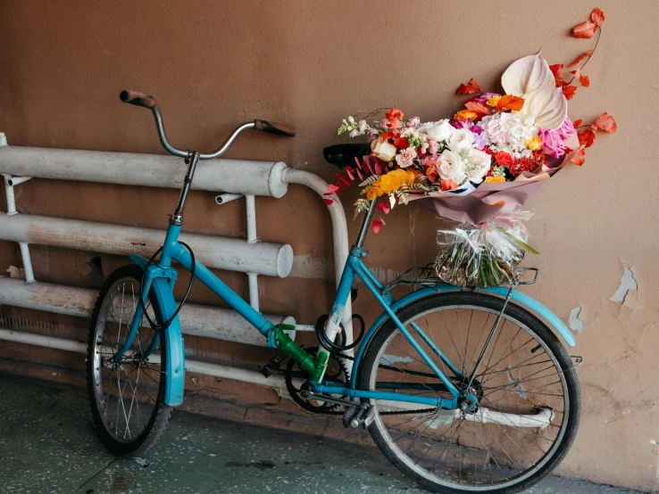 an image of blue bicycle with flowers on the back