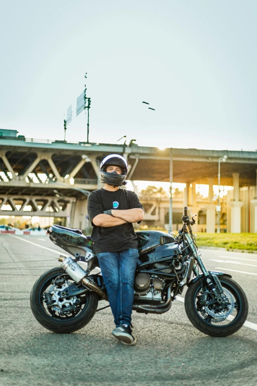 man sitting on black motorcycle, on roadway