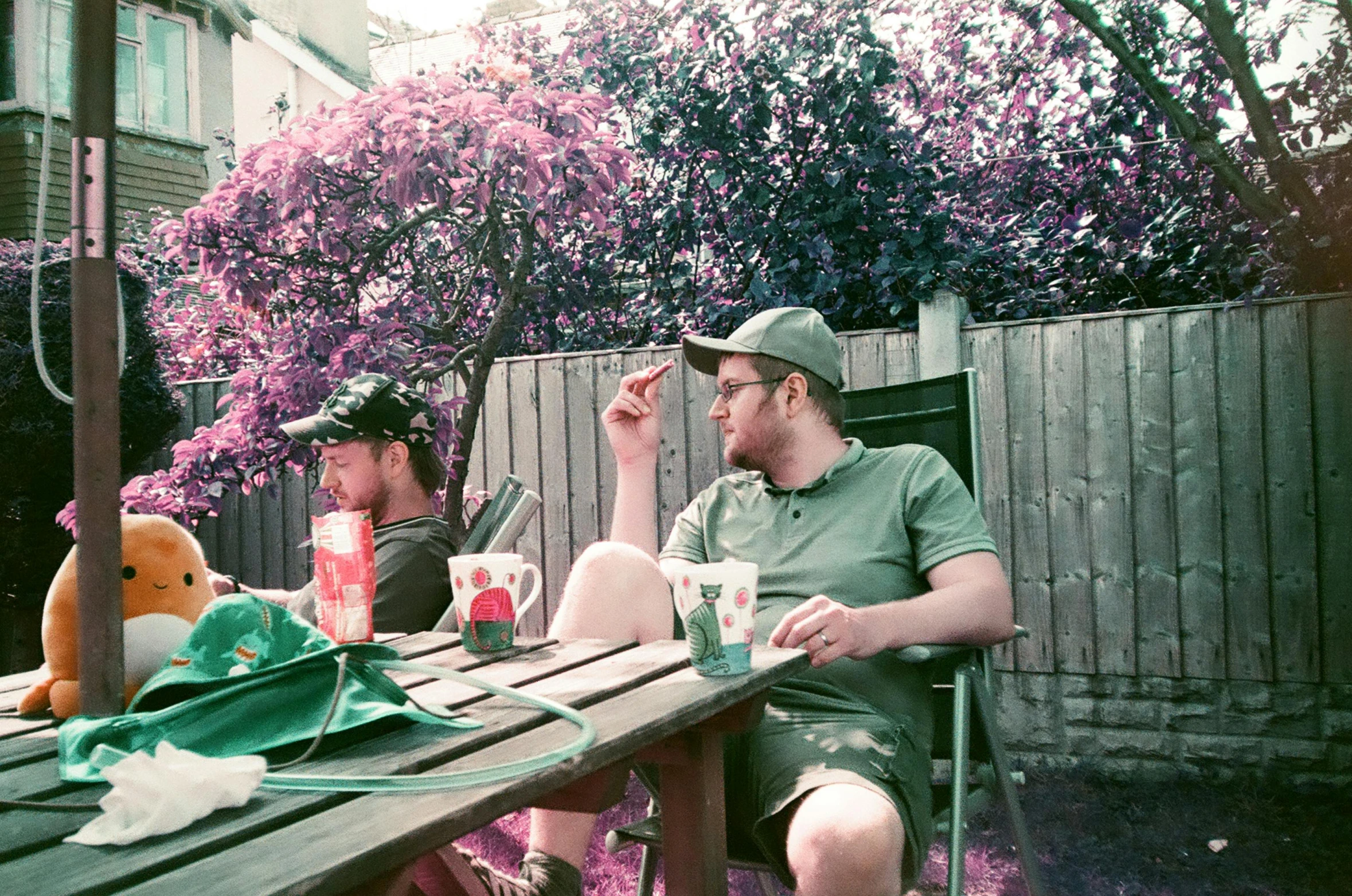 there are two men sitting at the table with drinks and snacks