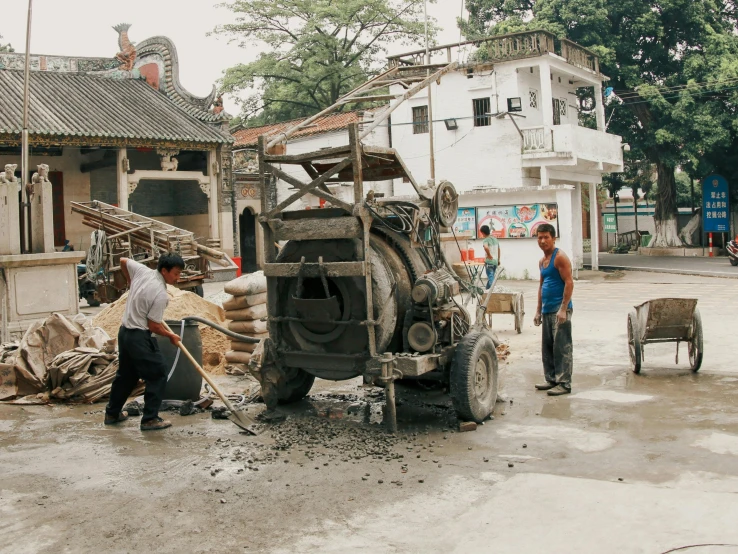 some people in a construction area near an elephant and a man