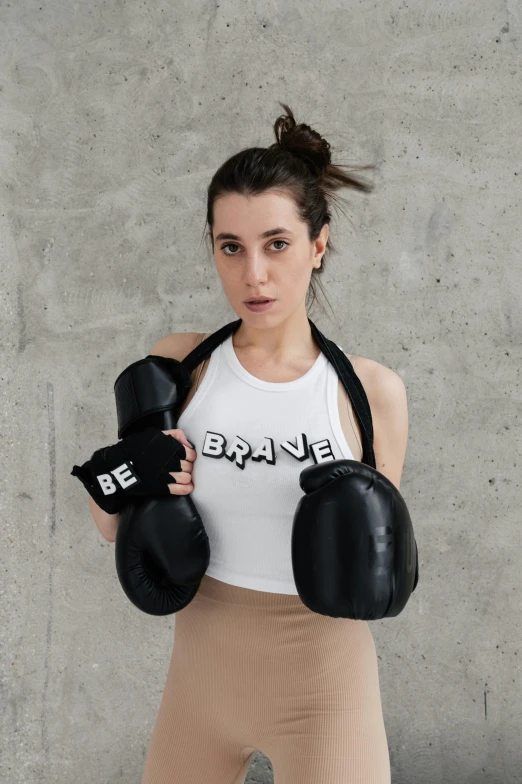 a girl holding two pairs of boxing gloves