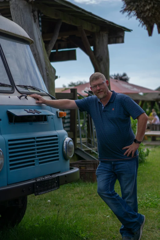 a man standing in front of a bus on a field