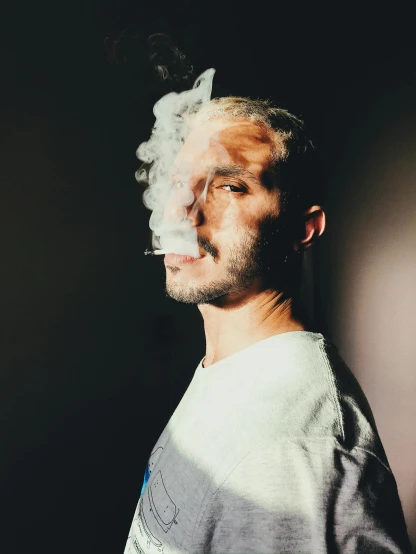 a man with his head smoking a cigarette