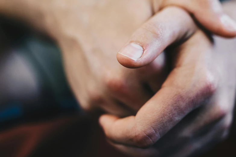 the fingers of someone holding a piece of paper