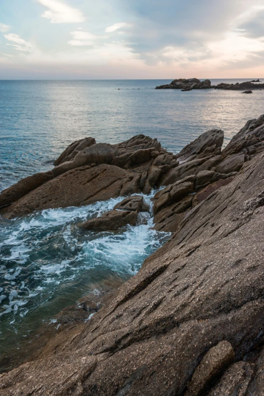 an ocean and a rocky shore with some water