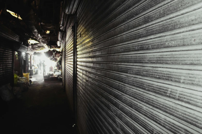 a person in a dark alley next to an industrial building