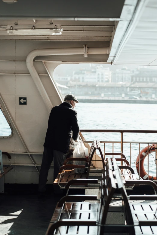 a man standing on top of a boat next to benches