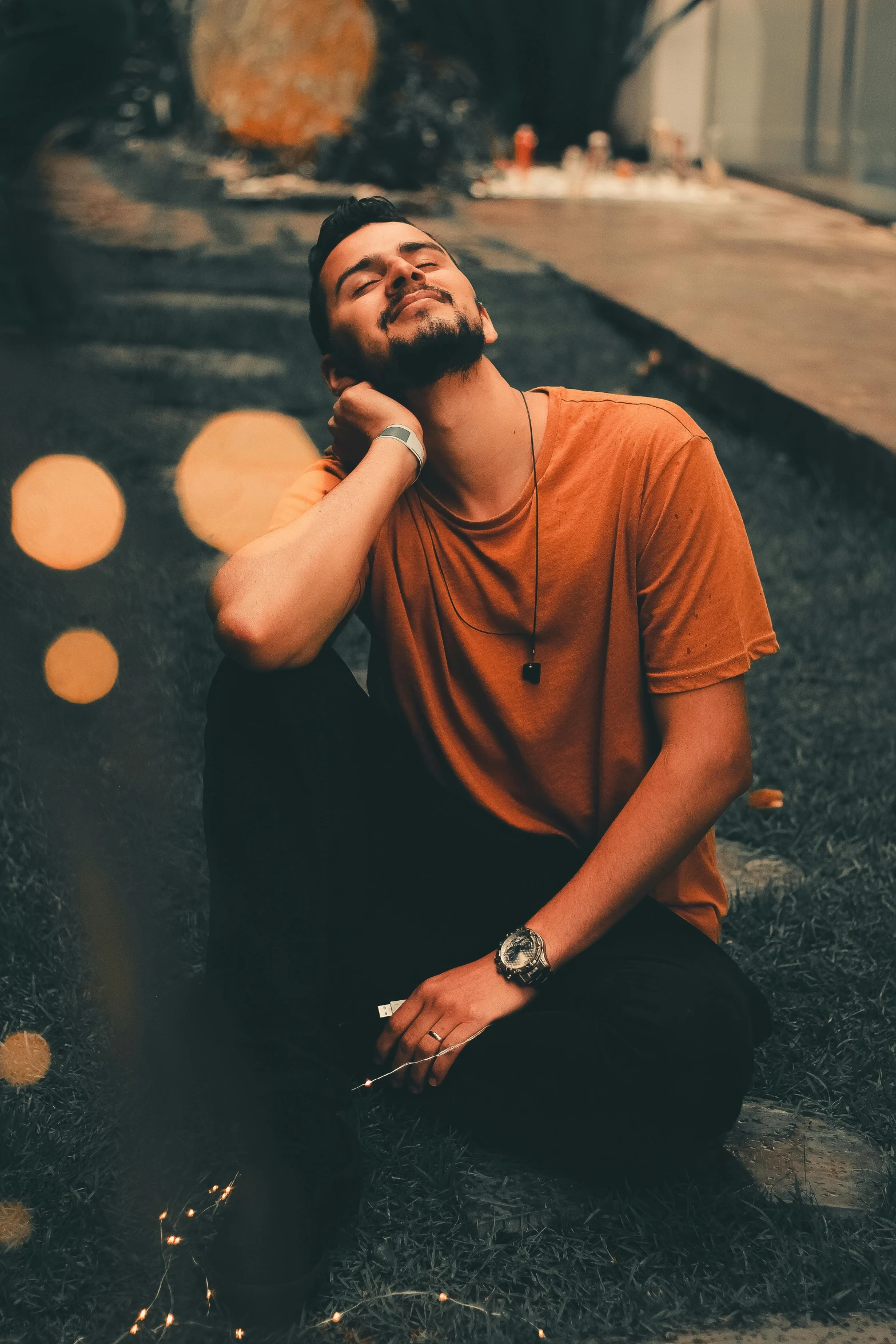 a man is sitting on the sidewalk with his head in his hands