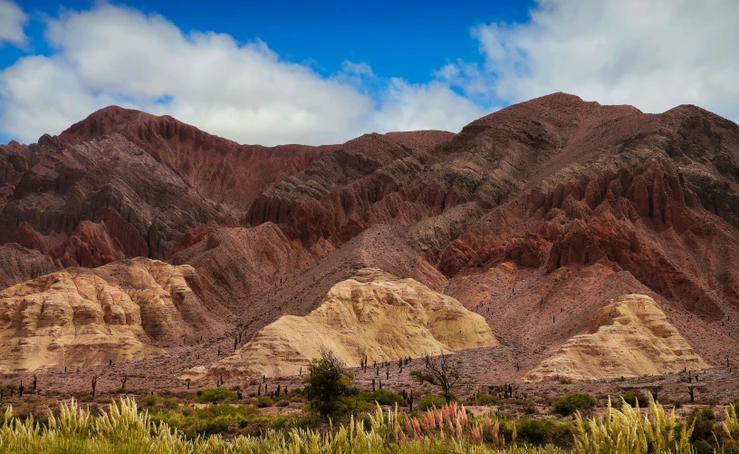 the mountain range shows a very large amount of red, white, and blue clouds