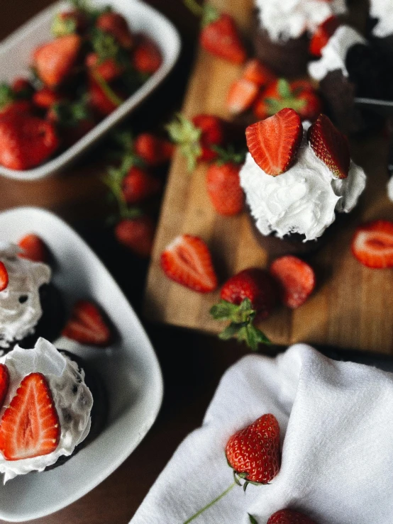 strawberries in bowls on  board on table