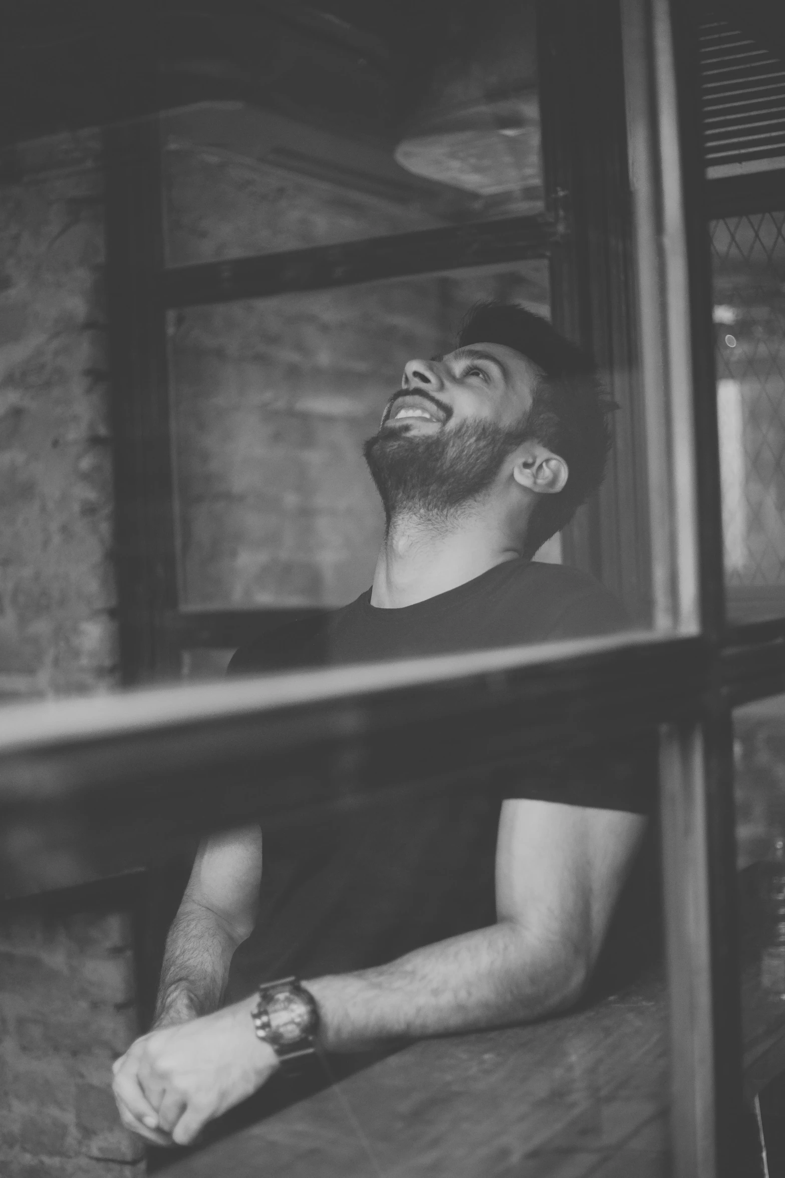 a man laughs while sitting inside of a small house