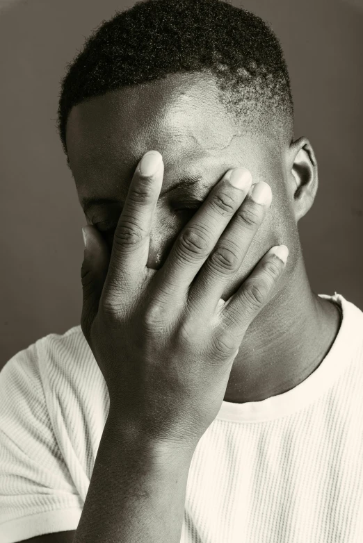 a man covering his face with his hand