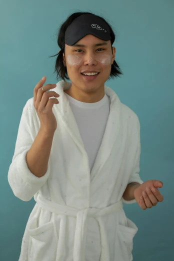 a woman wearing a white robe and hat posing for a picture