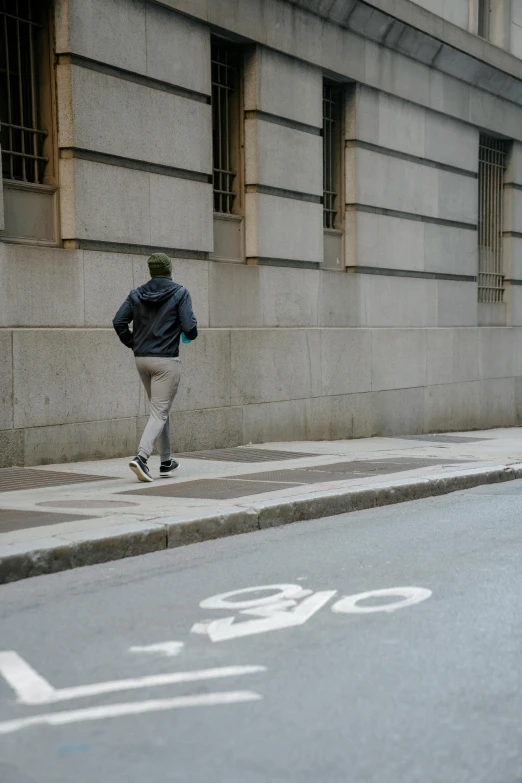 a man running down a sidewalk by a bike lane