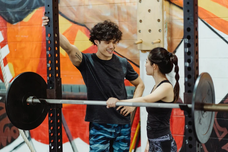 two people standing behind barbells in a gym