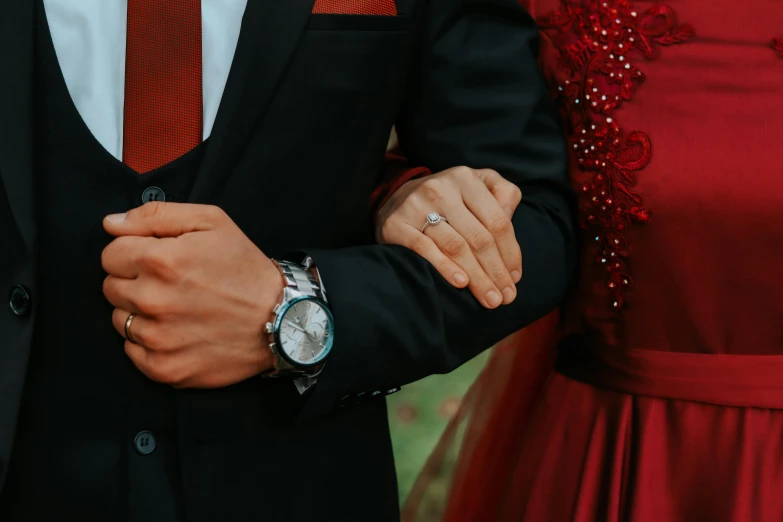 man and woman with red dress and gold ring on their wrist