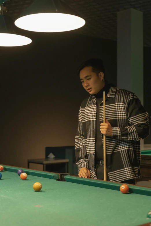 a man standing in front of a pool table