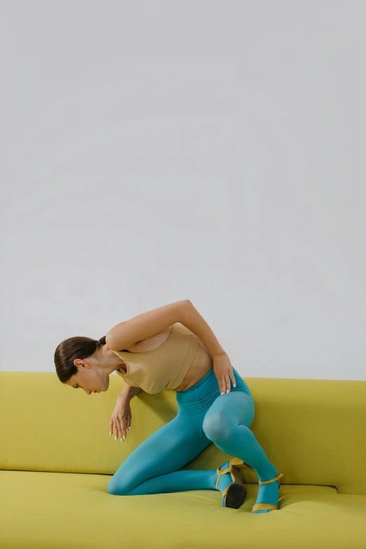 a woman stretching on a sofa against a wall