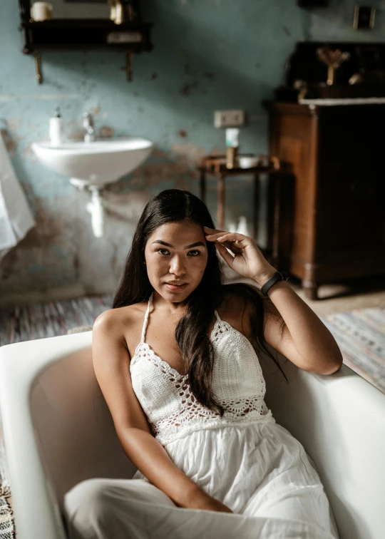 a woman is posing in a bathtub next to the sink