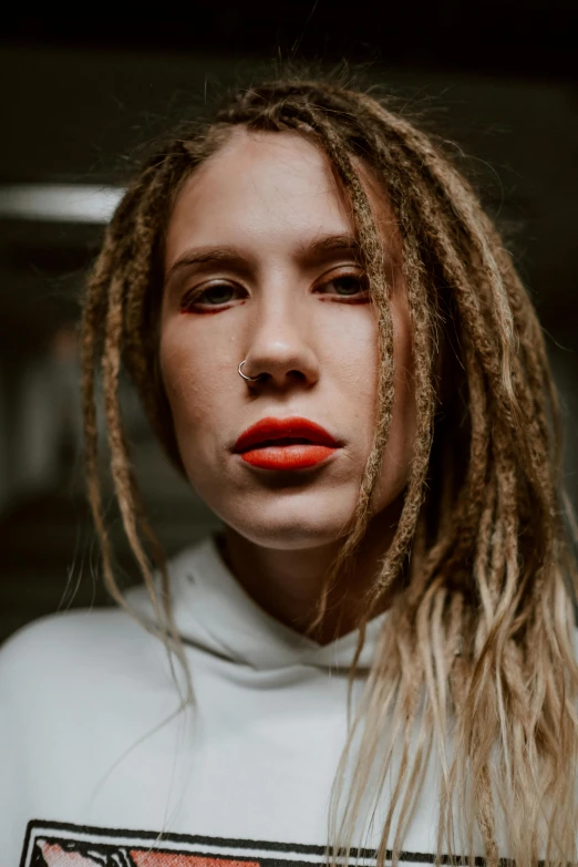 a young woman with dreadlocks and red lipstick