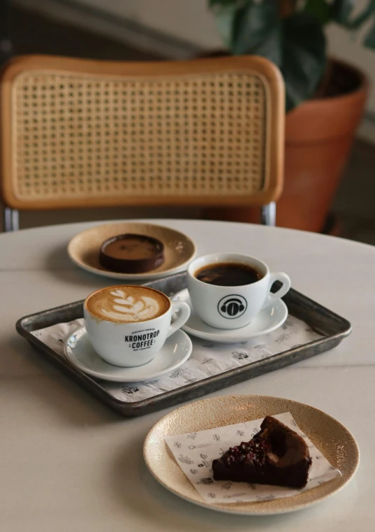 a table topped with plates of cake and cups of coffee